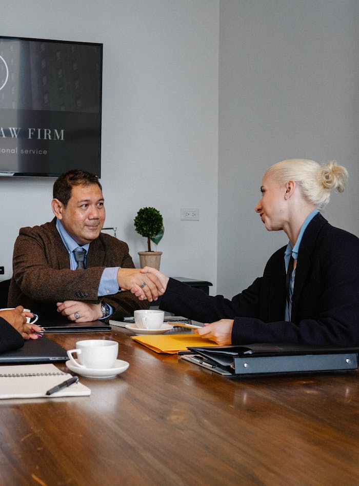 Executives shaking hands in a business meeting, signifying agreement and partnership.